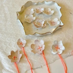 Porseleinen bloemen (10) met oranje draad